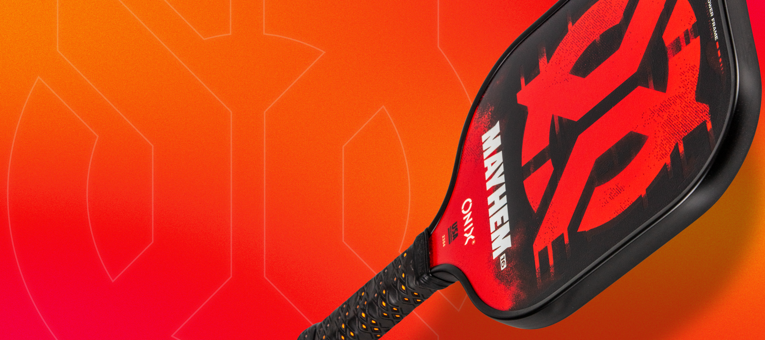 A photo of an Onix Mayhem Pickleball Paddle on an Orange Background