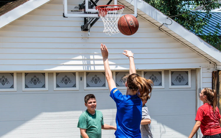 Kids playing basketball in their backyard